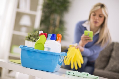 Local technician cleaning a sofa in a Belsizepark flat